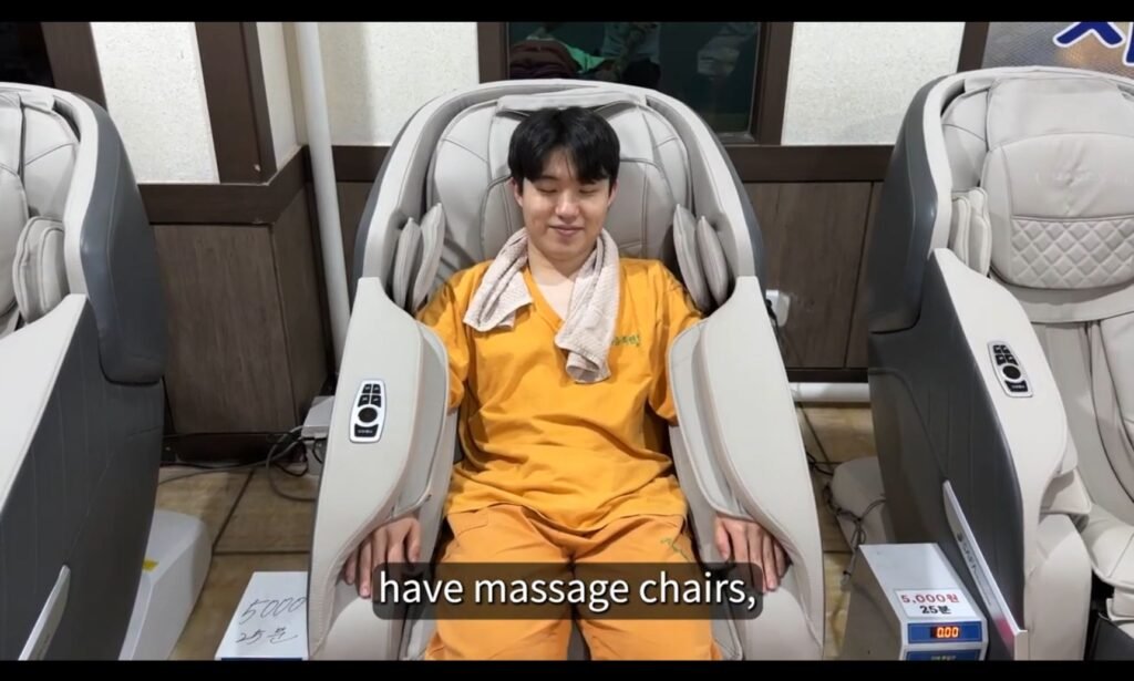 Bae wearing the facility’s spa outfit and a towel while seated in a massage chair