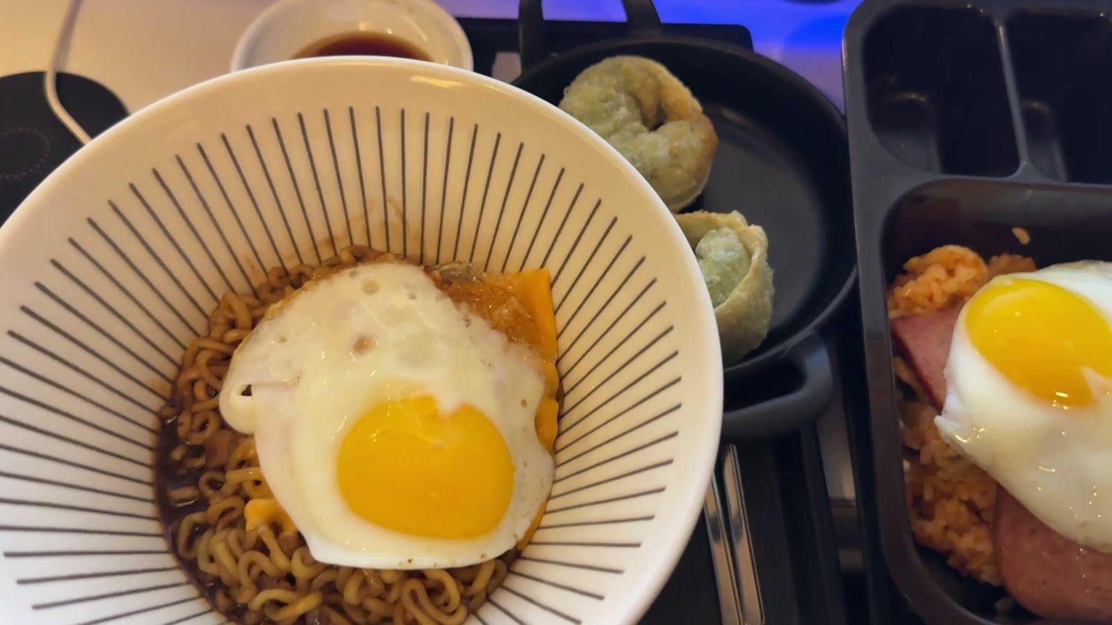 Chapagetti topped with a fried egg, dumplings and kimchi fried rice with Spam at the PC café